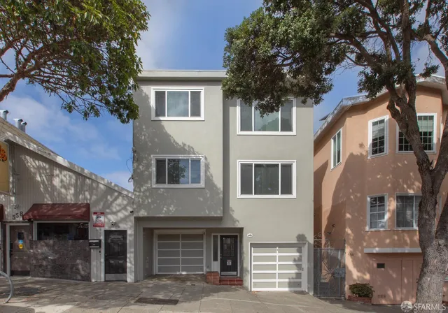 a front view of a house with a tree