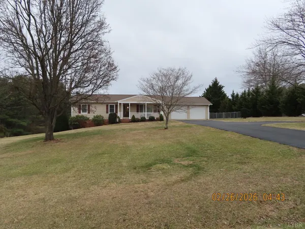 a front view of house with yard and trees in the background