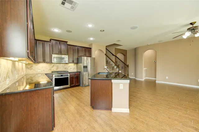 a kitchen with stainless steel appliances granite countertop a stove a sink and a refrigerator