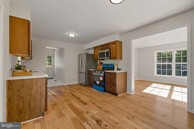 a view of a kitchen with a sink dishwasher cabinets and wooden floor