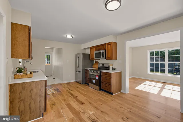 a kitchen with stainless steel appliances granite countertop a sink stove and wooden floor