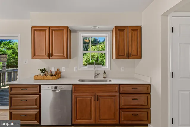 a view of an empty room with furniture and a window