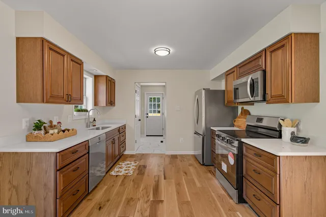 a kitchen with a sink stove top oven and refrigerator