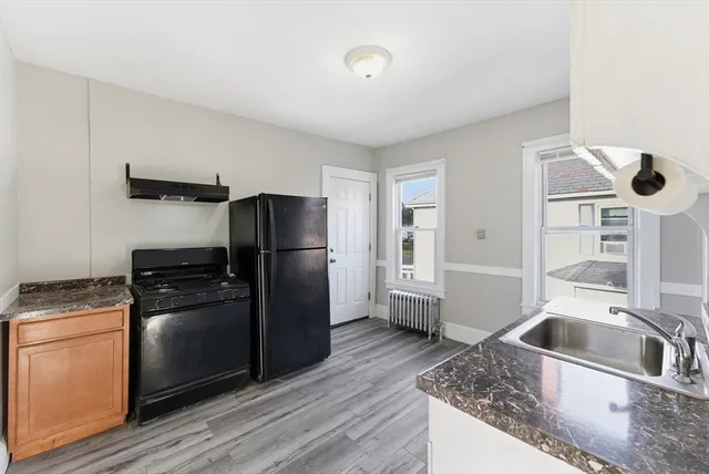 a kitchen with granite countertop a refrigerator and a sink