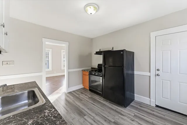 a kitchen with a refrigerator cabinet and a sink