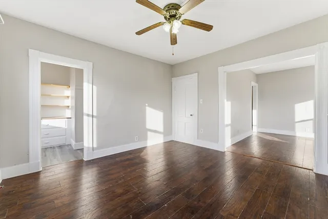a view of an empty room with window and wooden floor