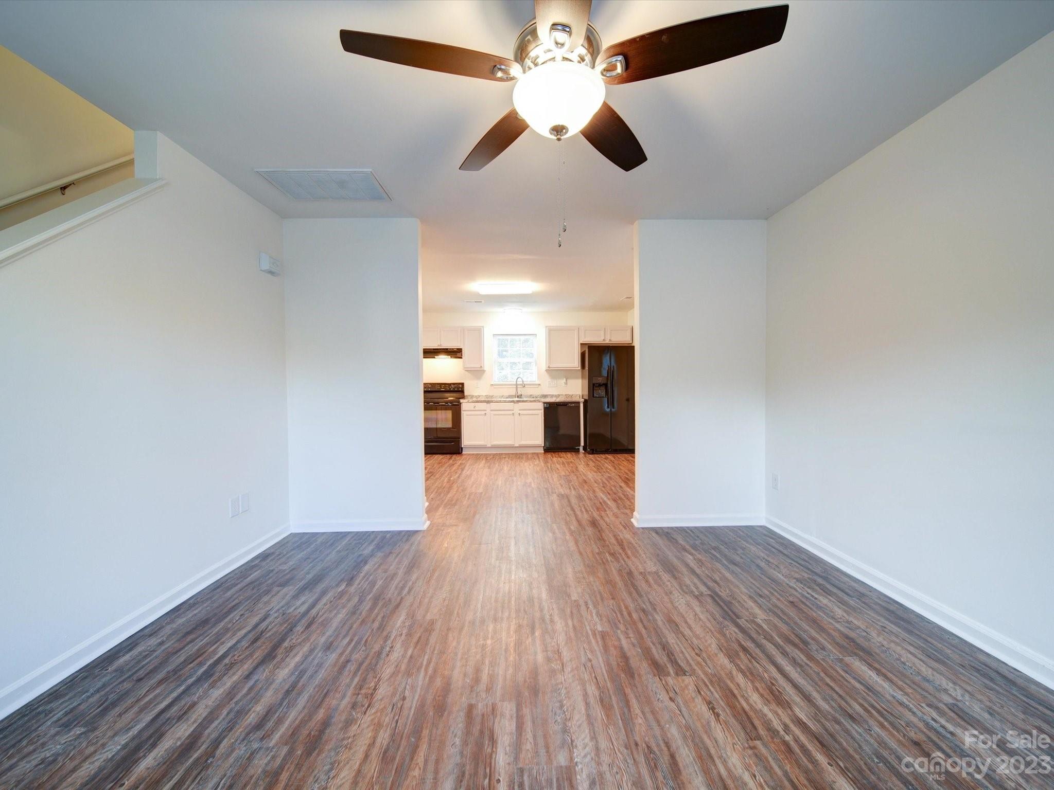 925 Key Street Charlotte, NC 28208 - Photo 12 of 41 a view of a big room with wooden floor a ceiling fan and windows