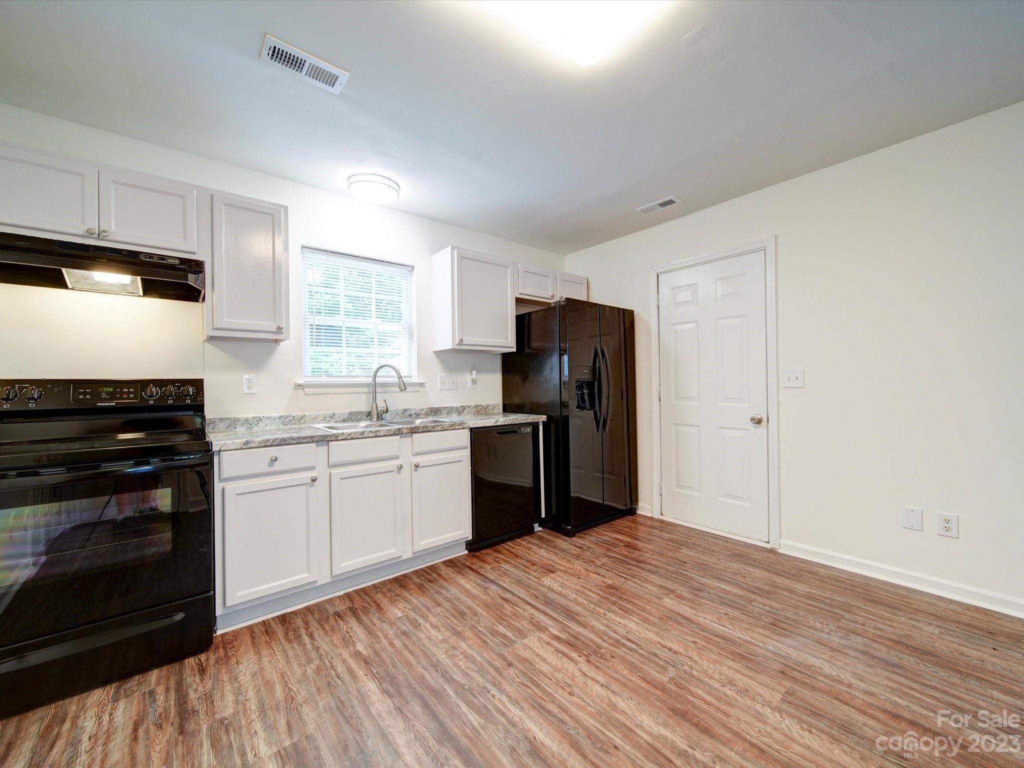 925 Key Street Charlotte, NC 28208 - Photo 15 of 41 a kitchen with refrigerator cabinets and wooden floor