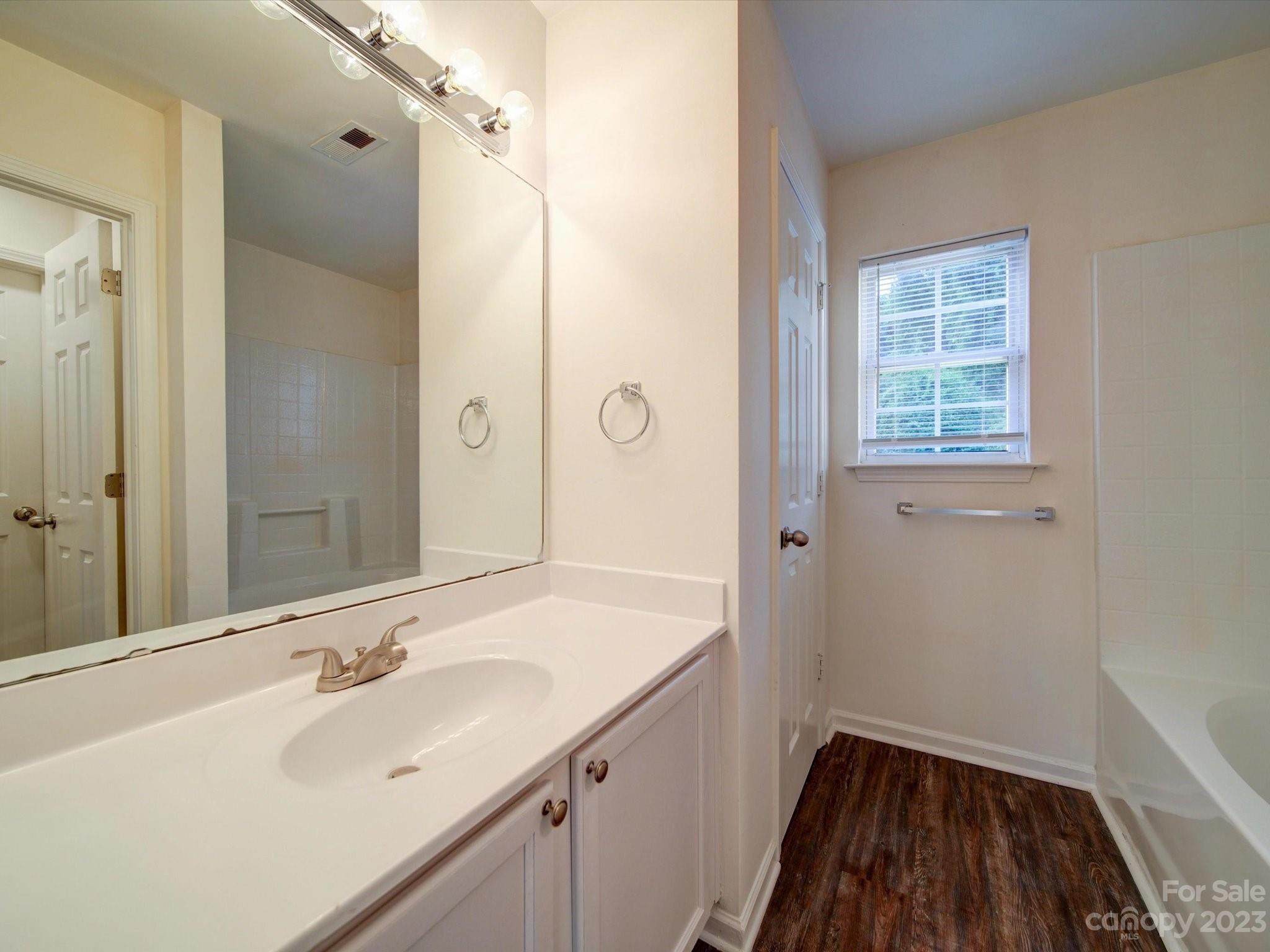 925 Key Street Charlotte, NC 28208 - Photo 20 of 41 a bathroom with a sink a mirror a vanity and a shower