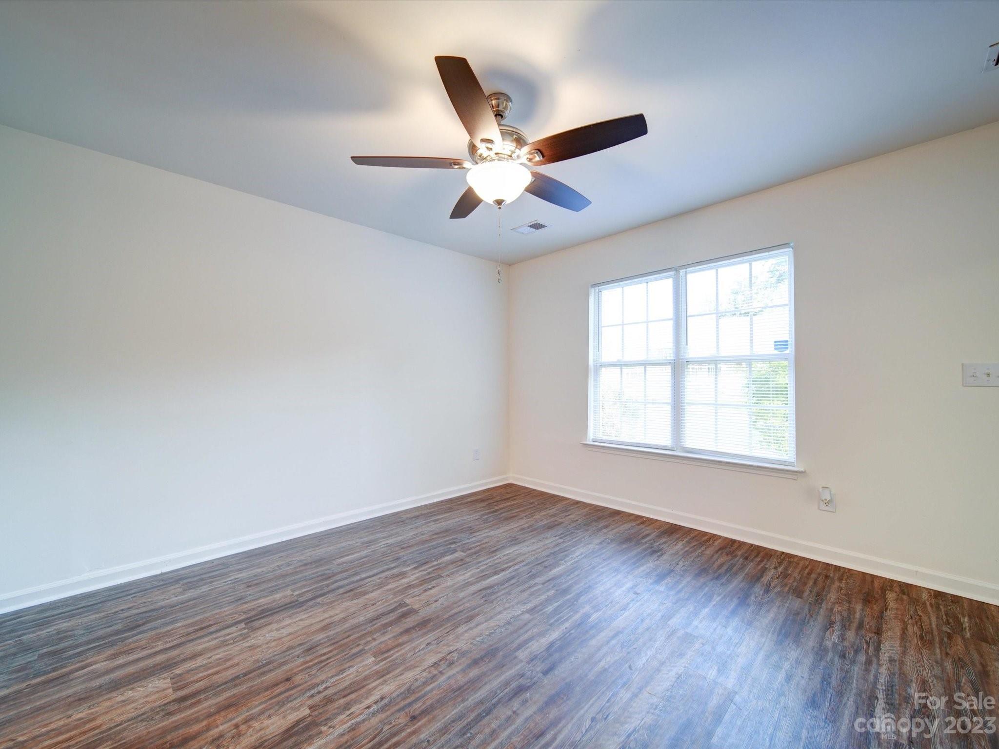 925 Key Street Charlotte, NC 28208 - Photo 9 of 41 an empty room with wooden floor fan and windows