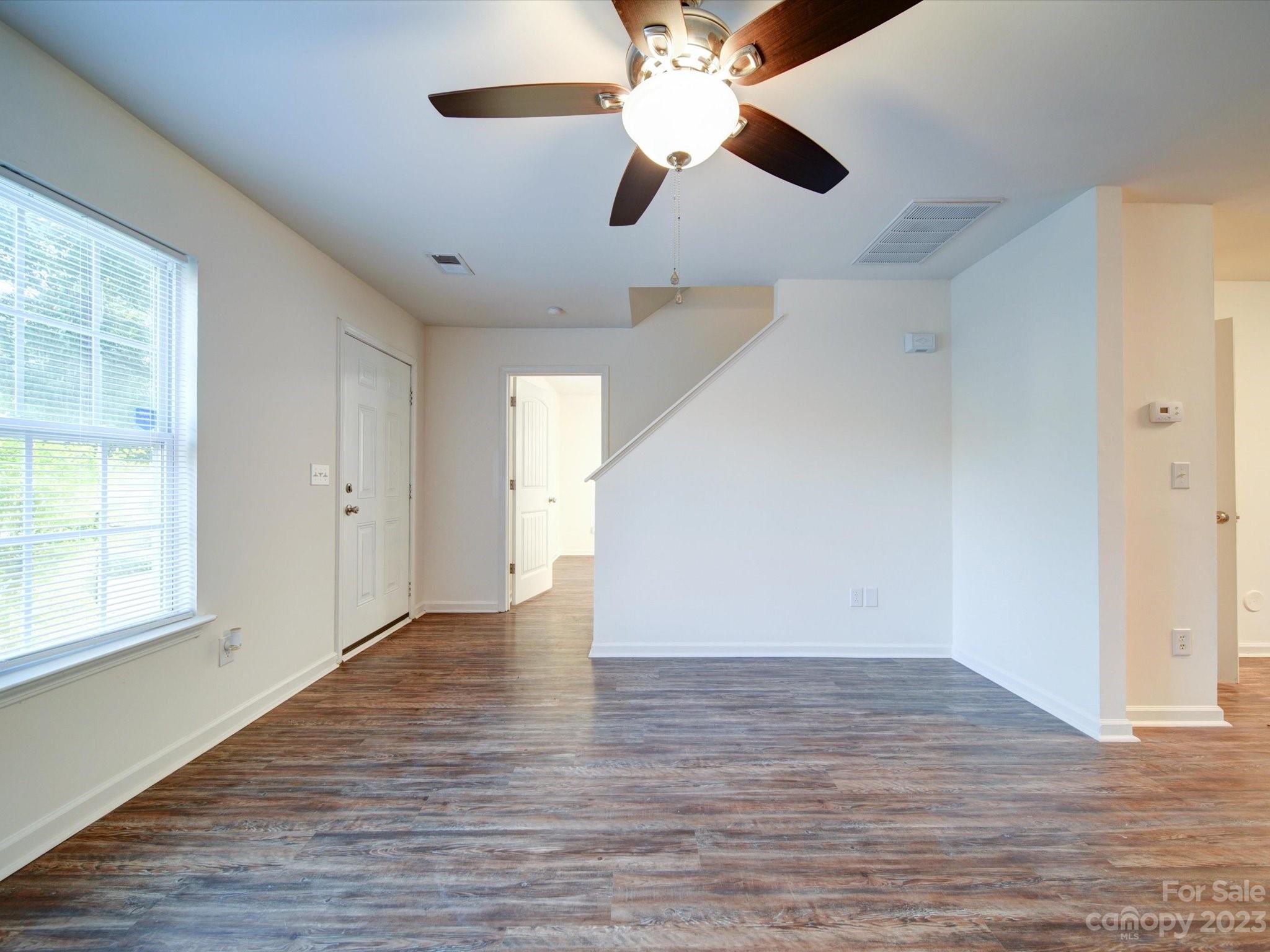 925 Key Street Charlotte, NC 28208 - Photo 10 of 41 an empty room with wooden floor chandelier fan and windows