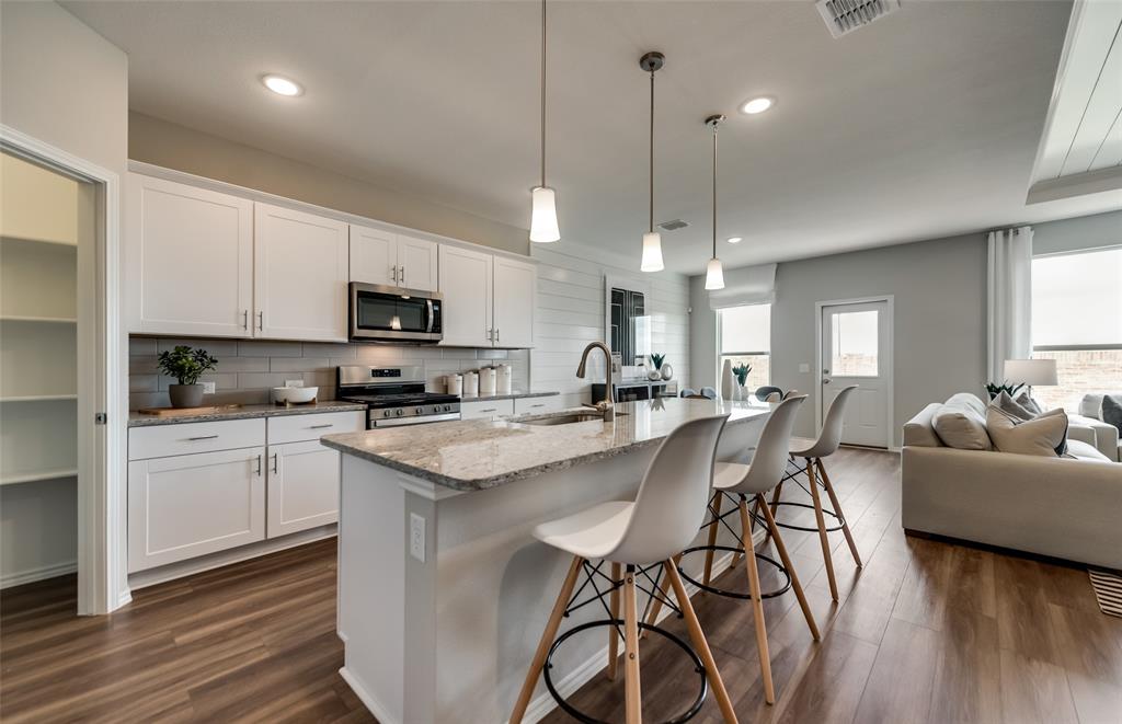 816 Shire Avenue Haslet, TX 76052 - Photo 2 of 23 a kitchen with stainless steel appliances granite countertop a stove a sink a kitchen island with a dining table and chairs