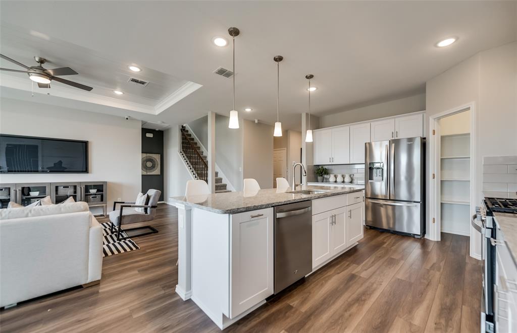 816 Shire Avenue Haslet, TX 76052 - Photo 4 of 23 a kitchen with stainless steel appliances kitchen island hardwood floor sink and stove