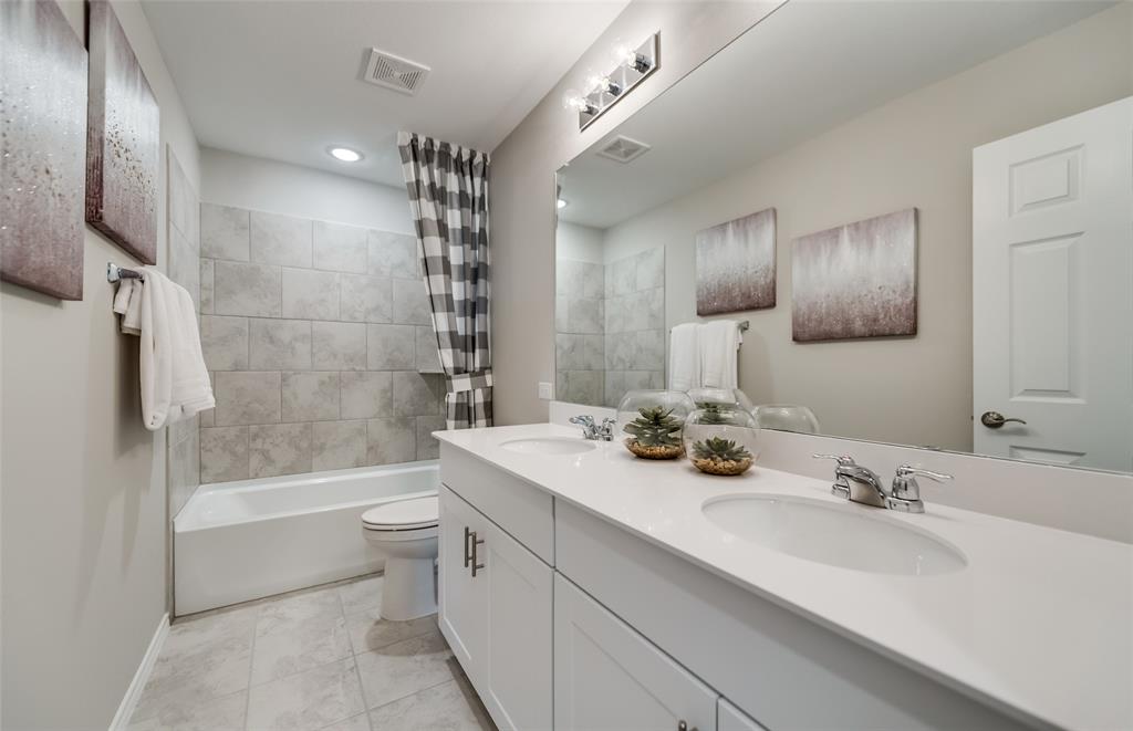 816 Shire Avenue Haslet, TX 76052 - Photo 10 of 23 a bathroom with a tub sink toilet and a mirror