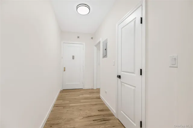 a view of a hallway with wooden floor and a bathroom