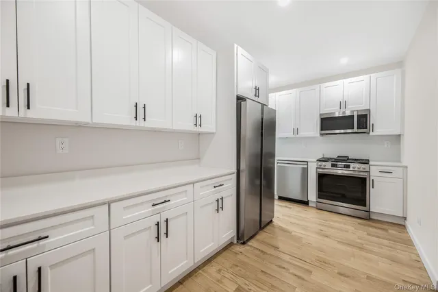 a kitchen with white cabinets and stainless steel appliances