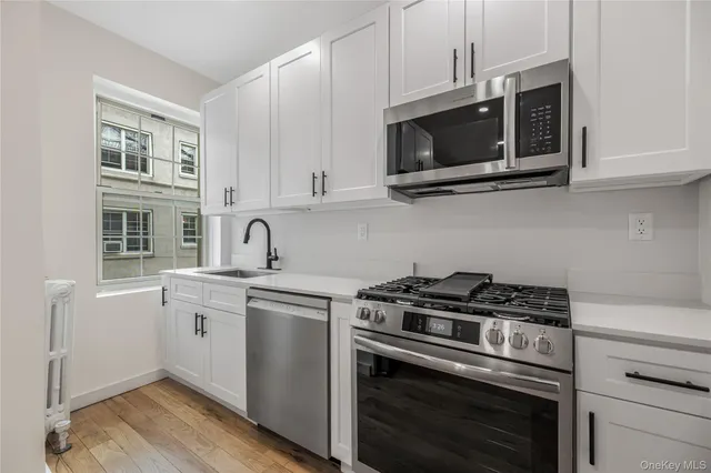 a kitchen with stainless steel appliances granite countertop a stove microwave and sink