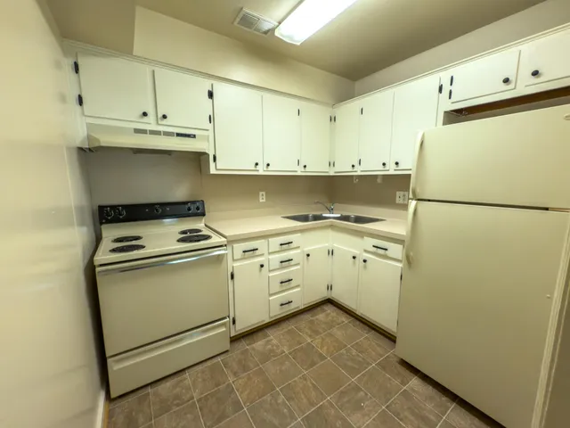 a kitchen with white cabinets and white appliances