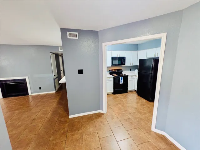 a view of a kitchen with refrigerator and windows