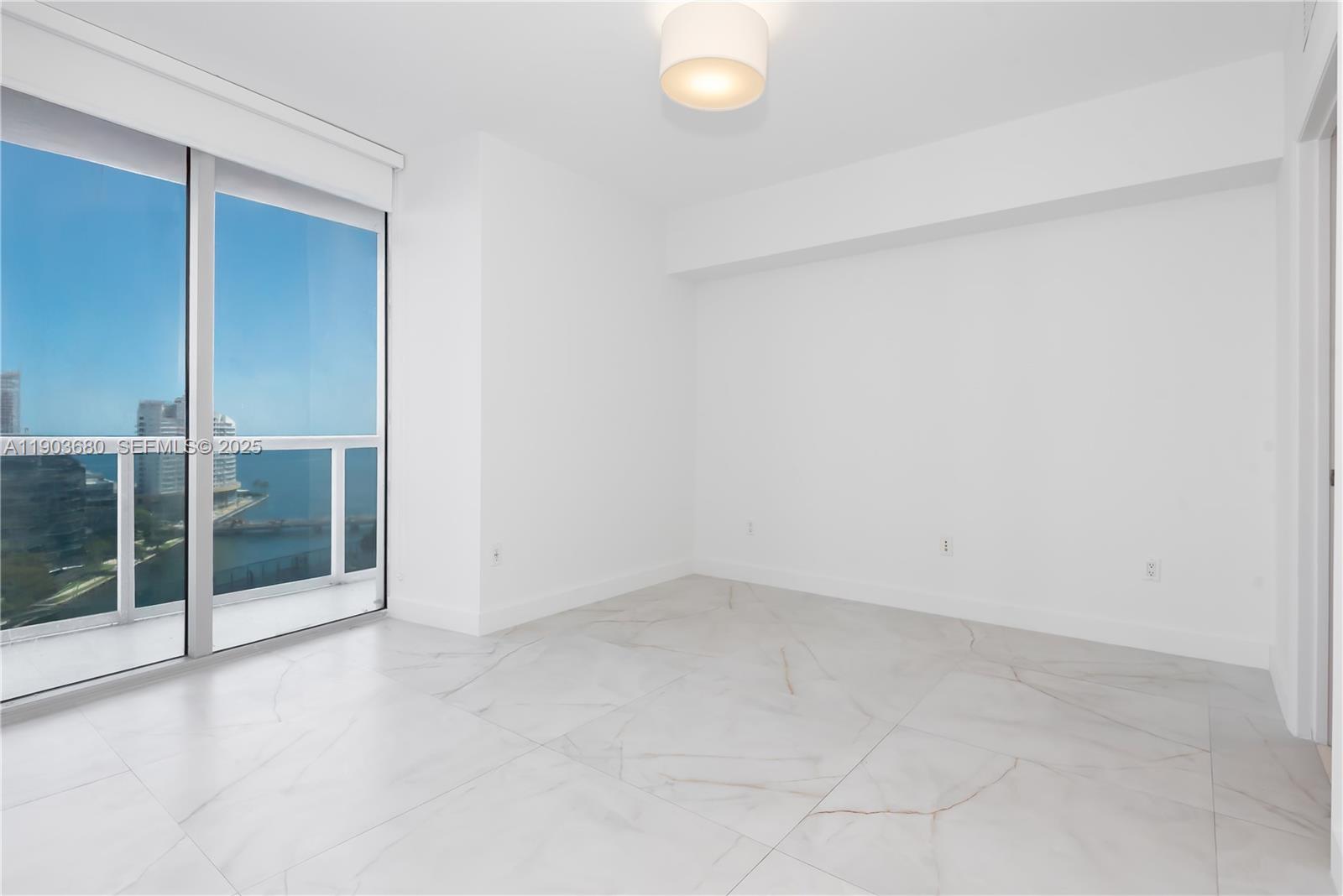 465 Brickell Avenue, Unit 1705 Miami, FL 33131 - Photo 13 of 34 an empty room with sliding glass door