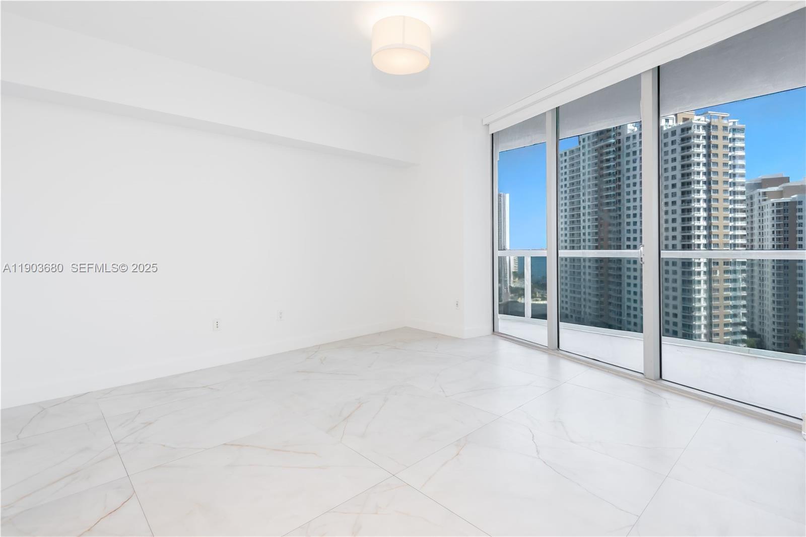 465 Brickell Avenue, Unit 1705 Miami, FL 33131 - Photo 32 of 34 an empty room with sliding glass door and shower