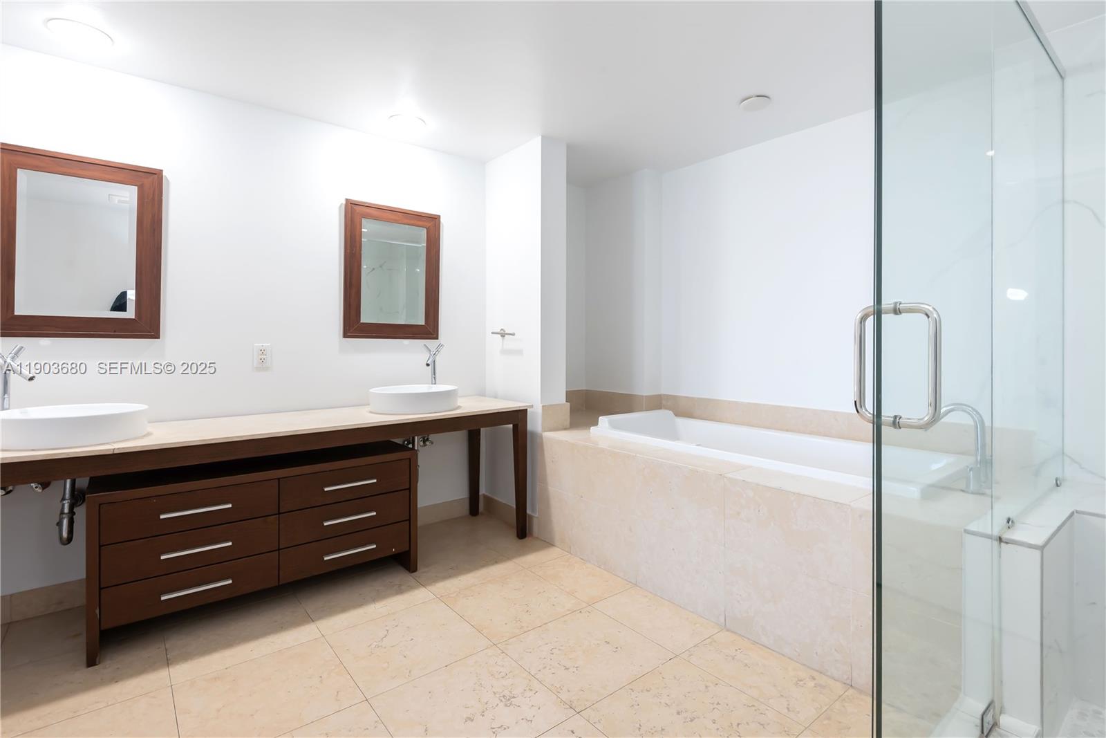 465 Brickell Avenue, Unit 1705 Miami, FL 33131 - Photo 33 of 34 a bathroom with a bathtub sink and a mirror