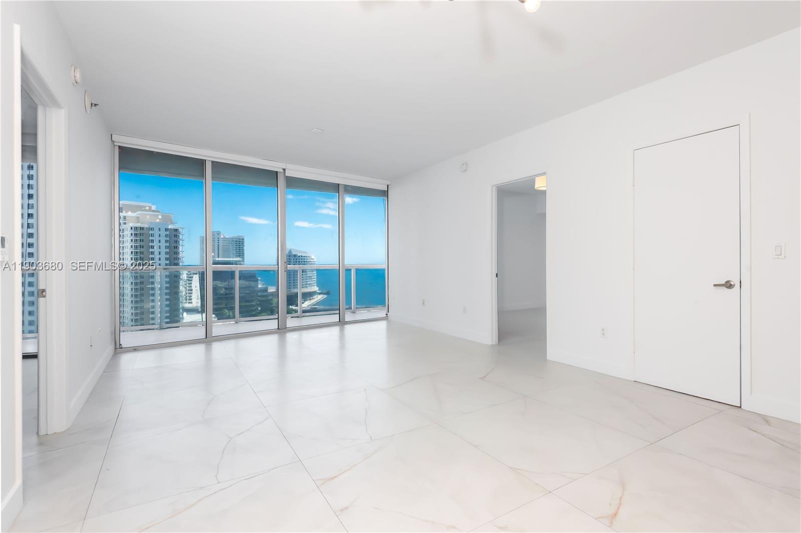 465 Brickell Avenue, Unit 1705 Miami, FL 33131 - Photo 5 of 34 an empty room with floor to ceiling window