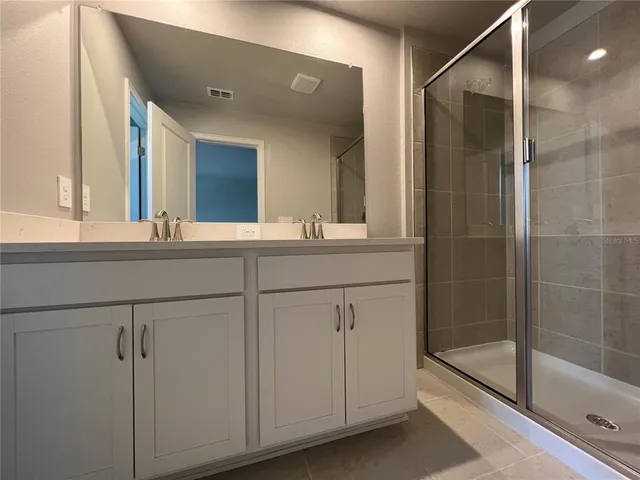 a bathroom with a shower sink and mirror