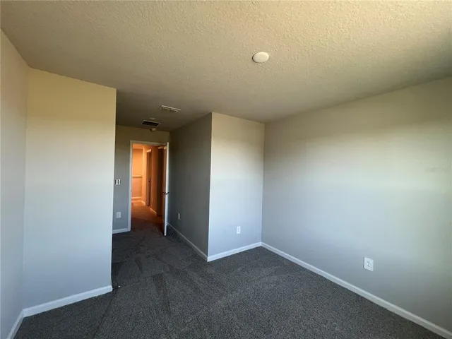 an empty room with closet and windows