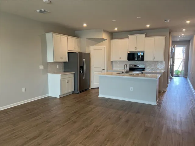 a kitchen with stainless steel appliances a refrigerator sink and microwave