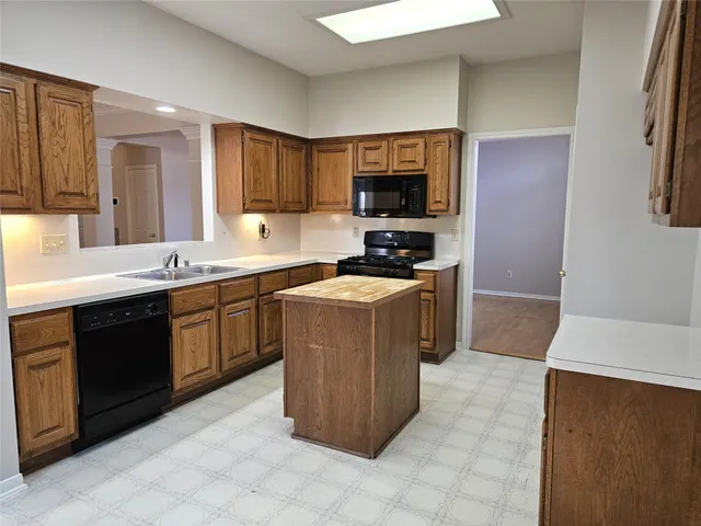 a kitchen with a sink a stove top oven a counter space and cabinets