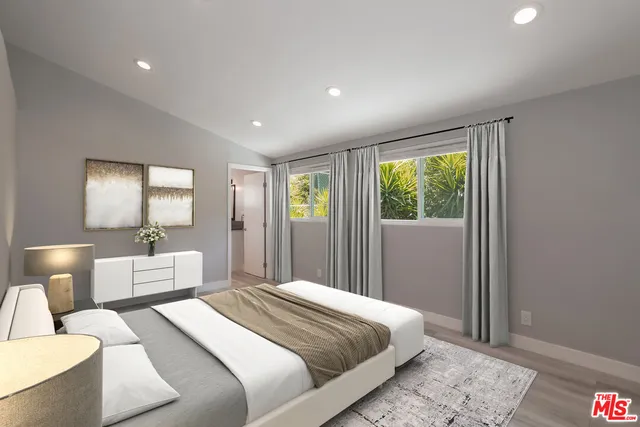 a bedroom with a large bed and a window