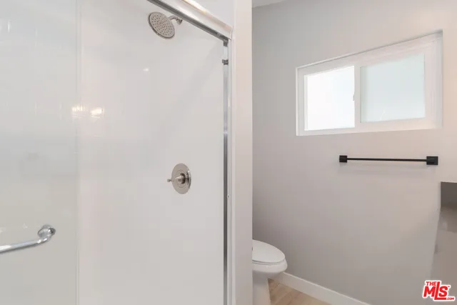 a bathroom with a granite countertop toilet and a shower
