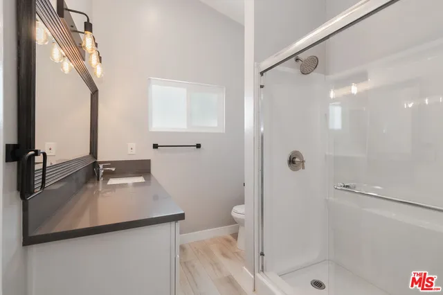 a bathroom with a shower sink and mirror