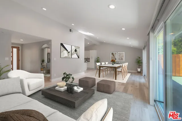 a living room with furniture and a view of kitchen