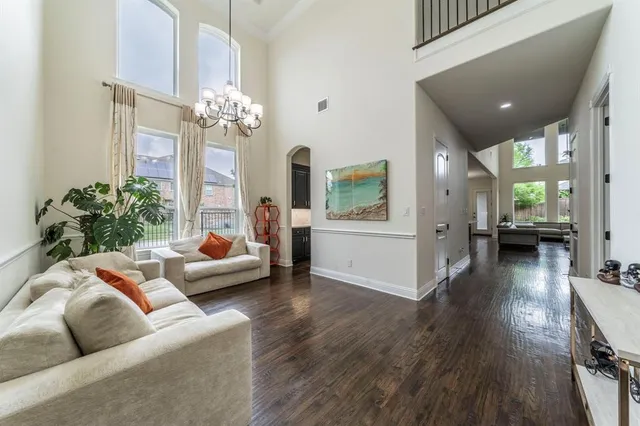 a dining room with wooden floor a chandelier a wooden table and chairs