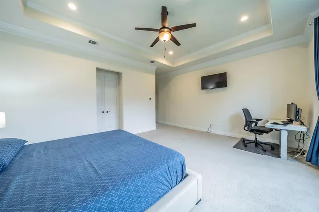 a bedroom with a bed and a lamp on the wall