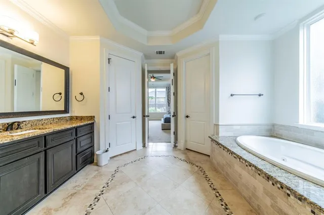 a spacious bathroom with a granite countertop sink and a large mirror
