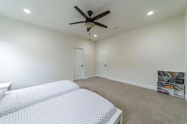 a living room with a bed furniture and a ceiling fan