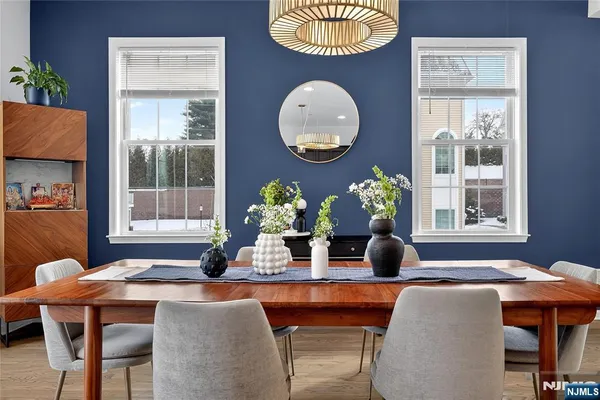 a view of a dining room and livingroom with furniture wooden floor a chandelier