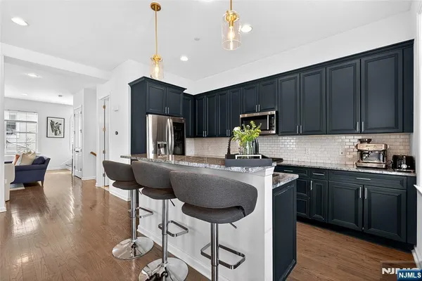 a kitchen with granite countertop a refrigerator and a stove top oven
