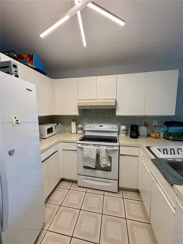 a kitchen with white cabinets and white appliances
