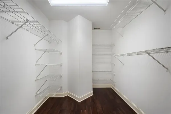 a view of walk in closet with empty racks