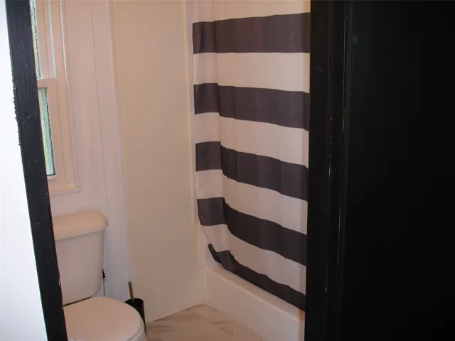 a bathroom with a toilet and a shower