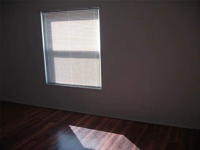 a bed room with wooden floor and a window