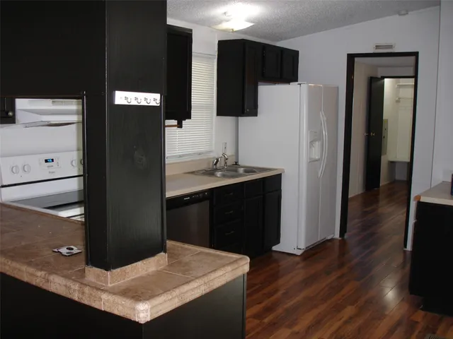 a kitchen with stainless steel appliances kitchen island sink refrigerator and stove