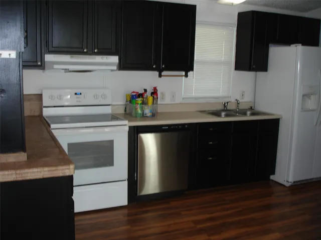 a kitchen with stainless steel appliances wooden cabinets and a sink