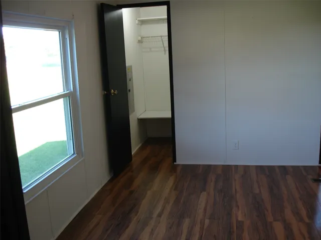 a view of a small space with wooden floor and a window