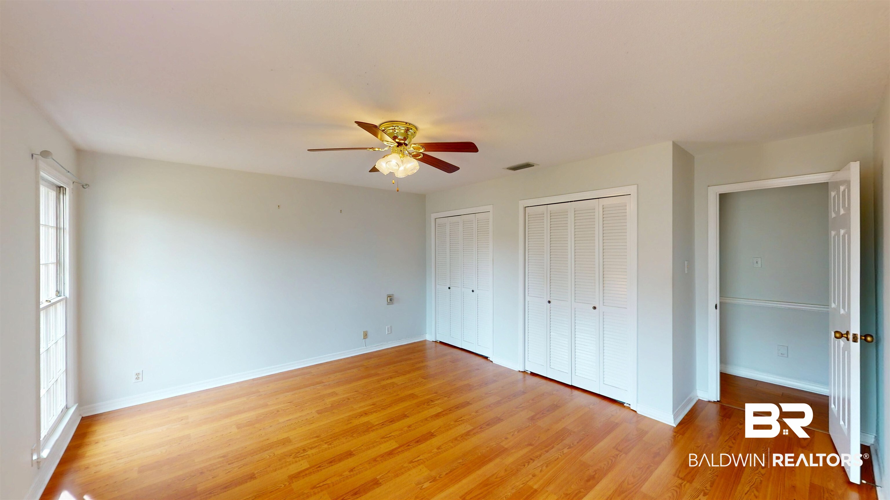 609 Burlington Court Mobile, AL 36608 - Photo 12 of 19 Unfurnished bedroom featuring multiple closets, light wood-type flooring, and ceiling fan