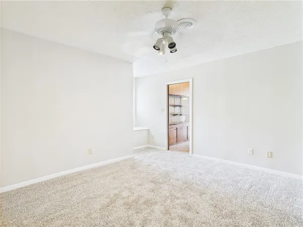 an empty room with a chandelier fan